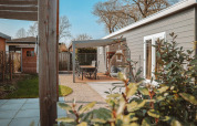 Udsigt over Veluwelodge XL ved Holiday park De Boshoek i Holland, med hyggelig terrasse og havemøbler.