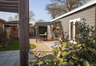 Terras bij Veluwelodge XL in vakantiepark De Boshoek, Nederland, met tuinset en comfortabele hangstoel.