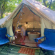 Indvendigt syn af Carvalho 4 Meter XL Bell Tent med blå stole, tæpper og hyggelig belysning i træer.