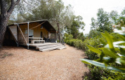 Tienda safari Villatent Wood en Camping Casa dei Prati, Italia, rodeada de árboles y vegetación natural.