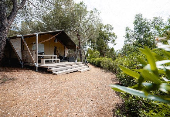 Safari tent Villatent Wood at Camping Casa dei Prati in Italy, surrounded by trees and natural greenery.