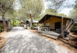 Tenda safari Villatent Wood al Camping Casa dei Prati in Italia, con veranda in legno e alberi intorno.