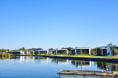 Villas modernas junto al lago en Villa Nautica, MarinaPark Residentie Nieuw Loosdrecht, Países Bajos, en un día soleado.