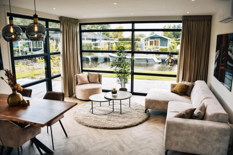 Salón moderno en Villa Nautica, MarinaPark Residentie Nieuw Loosdrecht, Países Bajos, con vista al canal.