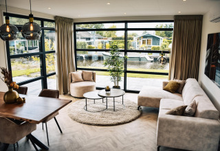 Salón moderno en Villa Nautica, MarinaPark Residentie Nieuw Loosdrecht, Países Bajos, con vista al canal.