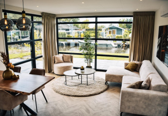 Salon élégant à la Villa Nautica, MarinaPark Residentie Nieuw Loosdrecht aux Pays-Bas, avec vue sur l’eau.