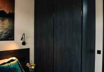 Moderne slaapkamer met donker kast en bed in Villa Nautica, MarinaPark Residentie Nieuw Loosdrecht, Nederland.