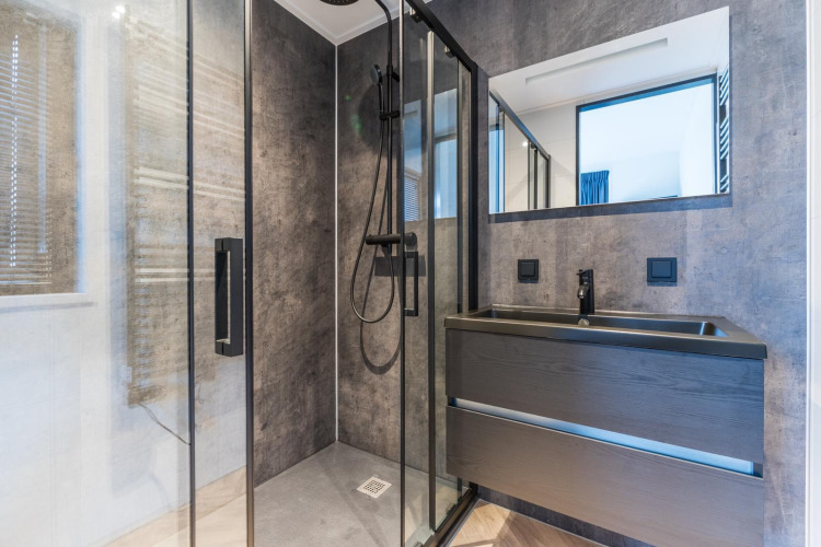 Modernes Badezimmer mit Glasdusche, dunklem Waschbecken und Spiegel in der Villa Nautica, MarinaPark Residentie Nieuw Loosdrecht.