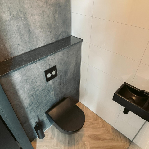 Modern zwart toilet en wastafel in badkamer bij Villa Nautica, MarinaPark Residentie Nieuw Loosdrecht, Nederland.