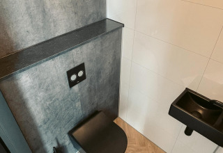 Modern zwart toilet en wastafel in badkamer bij Villa Nautica, MarinaPark Residentie Nieuw Loosdrecht, Nederland.