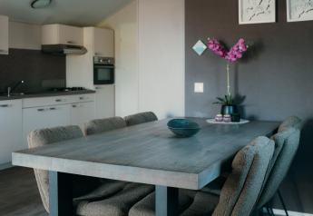 Zona pranzo moderna e cucina nella Veluwe lounge + sauna all’Holiday park De Boshoek, Paesi Bassi.