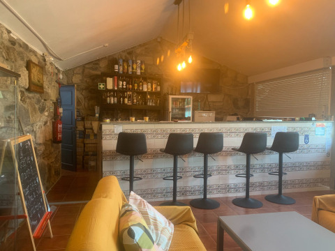 Bar interior acogedor con sillas modernas en Glamping de Cerveira, parque vacacional del norte de Portugal.
