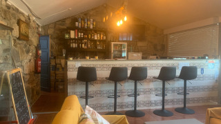 Bar interior acogedor con sillas modernas en Glamping de Cerveira, parque vacacional del norte de Portugal.