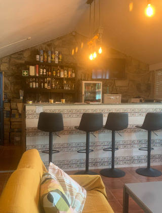 Bar interior acogedor con sillas modernas en Glamping de Cerveira, parque vacacional del norte de Portugal.