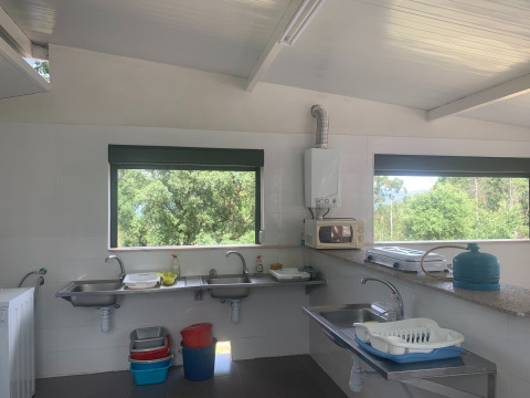 Cocina comunitaria luminosa en Glamping de Cerveira, un parque vacacional en el norte de Portugal.