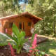Træhytte kaldet Azalea Cabin ved Glamping de Cerveira i Portugal, omgivet af frodig natur og blomster.