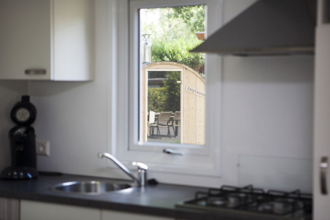 Kitchen view through window towards sauna at Veluwe lodge, Holiday park De Boshoek, Netherlands.