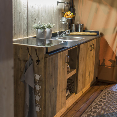 Pequeña cocina rústica de madera con fregadero en Glampinglodge GL, Holiday Park BreeBronne, Países Bajos.
