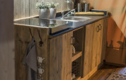 Rustic wooden kitchenette with sink and modern touches at Glampinglodge GL, BreeBronne, Netherlands.