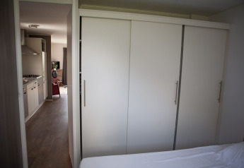 Vue de la chambre vers la cuisine et le salon dans une Veluwelodge au Holiday park De Boshoek, Pays-Bas.