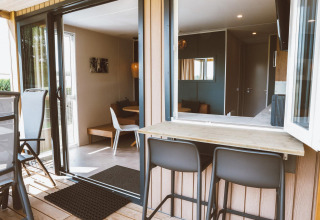 Innen- und Außenbereich eines Tiny Lodge im Holiday Park De Boshoek in den Niederlanden, modern eingerichtet.