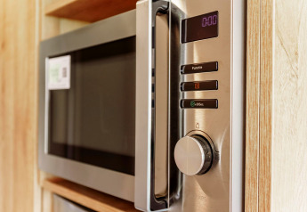 Forno a microonde moderno nella cucina compatta della Tiny Lodge all’Holiday park De Boshoek, Paesi Bassi.