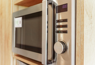 Modern microwave oven built into a small kitchen at Tiny Lodge, Holiday park De Boshoek, Netherlands.