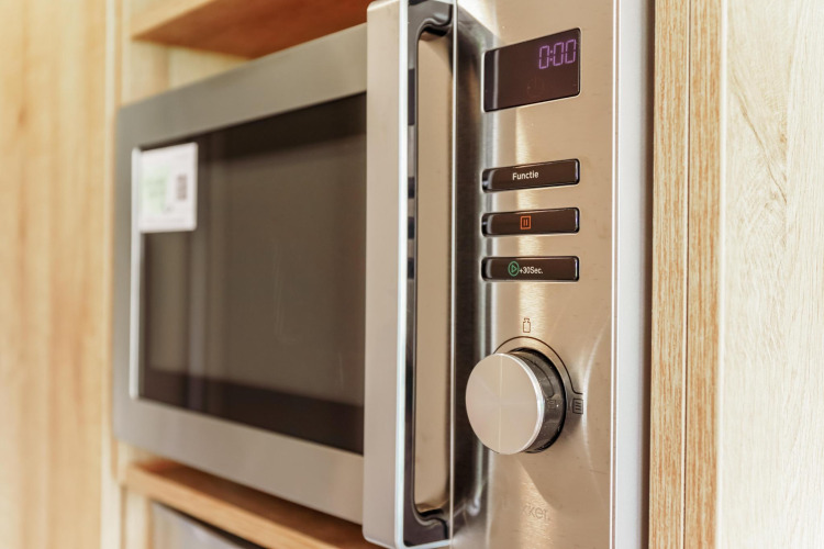 Moderne magnetron ingebouwd in de keuken van een Tiny Lodge bij Holiday park De Boshoek, Nederland.