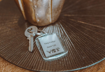 Key set with a 'Tiny Lodge Geel 125' tag on a table, taken at Holiday park De Boshoek in the Netherlands.