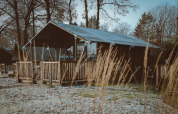Casetta tenda Safari Tiny Safari House con veranda in legno al parco De Boshoek nei Paesi Bassi in inverno.