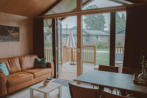 Udsigt fra stuen i Tiny Safari House på Holiday park De Boshoek, smuk indretning og udsyn til terrassen.