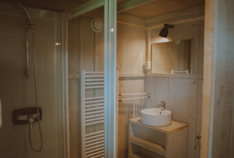 Badeværelse med brusekabine og vask i Tiny Safari House, feriepark De Boshoek, Holland.