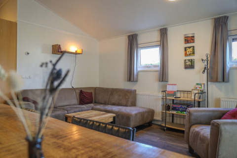 Soggiorno della Veluwe Lounge al parco vacanze De Boshoek nei Paesi Bassi, con divano e giochi da tavolo.
