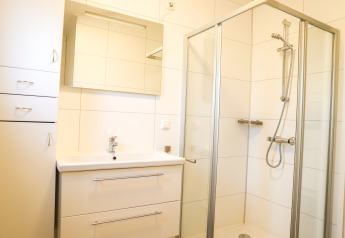 Moderne badkamer met douche, spiegel en wastafel in Veluwe Lounge, Holiday park De Boshoek, Nederland.