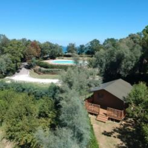 Vista aérea de una tienda safari con instalaciones sanitarias y piscina en Camping Paradiso, Italia.