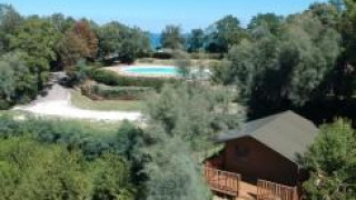 Luftfoto af en safariteltsplads med sanitære faciliteter og swimmingpool på Camping Paradiso i Italien.