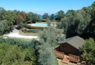 Vista aérea de una tienda safari con instalaciones sanitarias y piscina en Camping Paradiso, Italia.