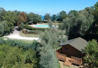 Luftfoto af en safariteltsplads med sanitære faciliteter og swimmingpool på Camping Paradiso i Italien.