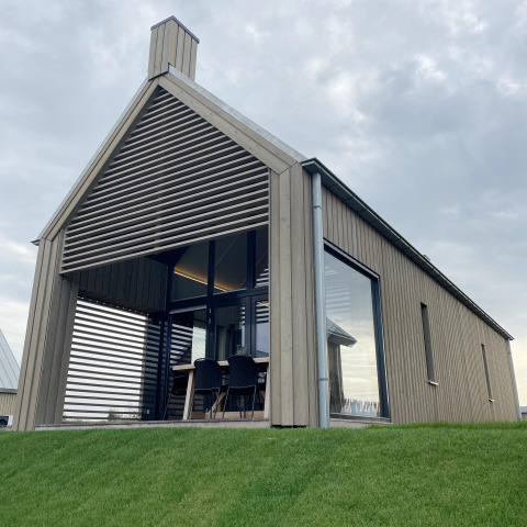 Moderne tiny house Villa Oesterdam Royal met grote ramen bij Oesterdam Resort in Nederland, buitenaanzicht.