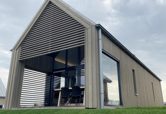 Moderne tiny house Villa Oesterdam Royal met grote ramen bij Oesterdam Resort in Nederland, buitenaanzicht.