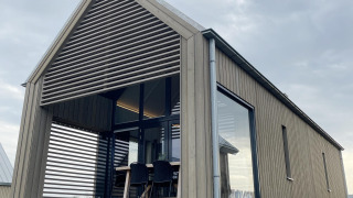 Moderne tiny house Villa Oesterdam Royal met grote ramen op Oesterdam Resort in Nederland, buitenaanzicht.