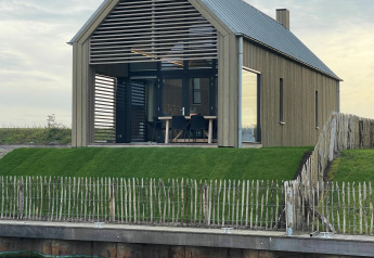 Villa Oesterdam Royal, una casa pequeña en Oesterdam Resort, Países Bajos, con diseño moderno junto al agua.