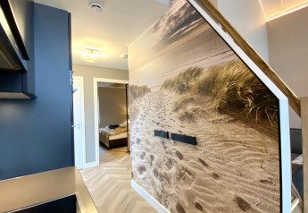 Interno moderno di una tiny house a Villa Oesterdam Royal, Oesterdam Resort, Paesi Bassi, con murale da spiaggia.