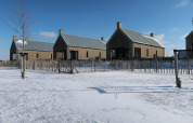 Moderne tiny houses bij Villa Oesterdam in Oesterdam Resort, Nederland, omgeven door sneeuw en houten hek.