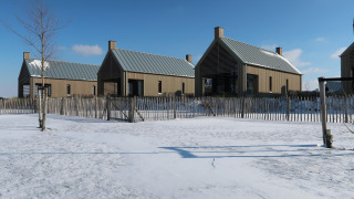 Moderne tiny houses bij Villa Oesterdam in Oesterdam Resort, Nederland, omringd door sneeuw en houten omheining.