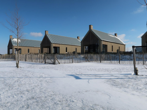 Moderne Tiny Houses bei Villa Oesterdam im Oesterdam Resort, Niederlande, umgeben von Schnee und Zaun.