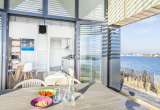 View from Villa Oesterdam at Oesterdam Resort in the Netherlands with patio, dining area and water view.