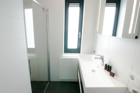 Modernes, kleines Badezimmer in der Villa Oesterdam, Oesterdam Resort, mit großem Fenster und schlichter Deko.