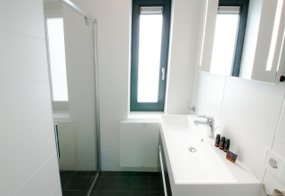 Modernes, kleines Badezimmer in der Villa Oesterdam, Oesterdam Resort, mit großem Fenster und schlichter Deko.