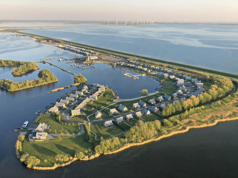 Vista aérea de Villa Oesterdam en Oesterdam Resort, Países Bajos, con casas pequeñas junto al agua.